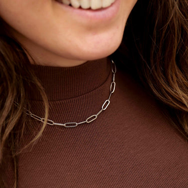 Stainless Steel Paperclip chain on model wearing a brown shirt