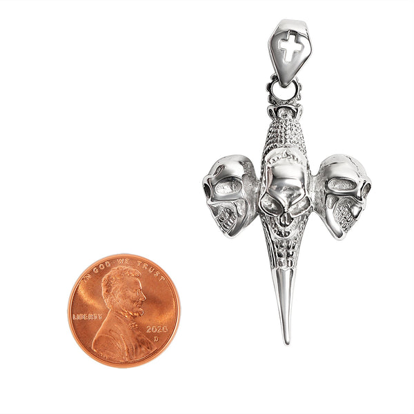 Stainless steel three skulls Cross pendant with a penny for scale.