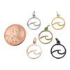 Stainless steel wave charms in a variety of colors with a penny for scale.