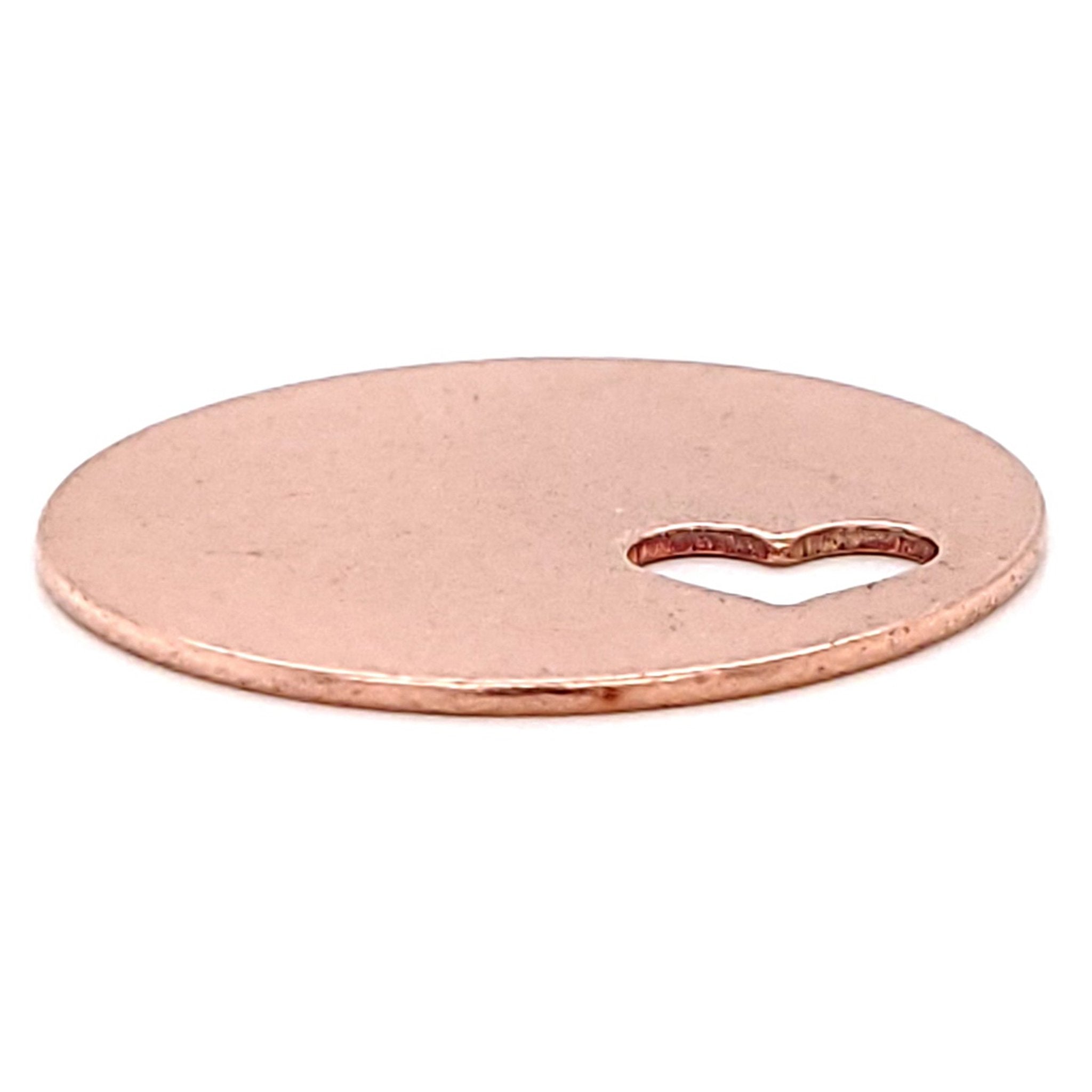 Copper blank round heart cutout pendant at an angle.