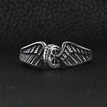 Stainless steel polished winged wheel ring on a black leather background.