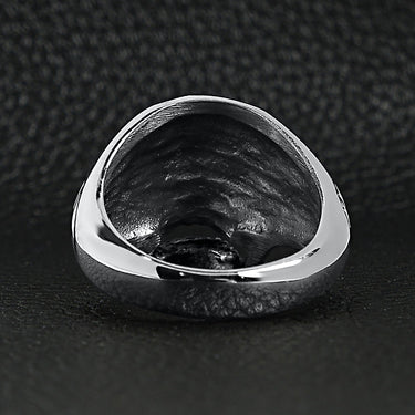 Stainless steel polished filigree skull ring back view on a black leather background.