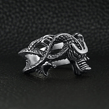 Stainless steel eastern dragon ring angled on a black leather background