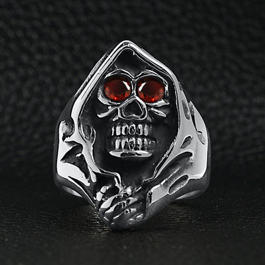 Stainless steel red Cubic Zirconia eyed grim reaper ring on a black leather background.