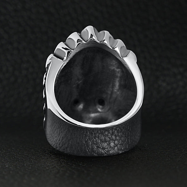Stainless steel black Cubic Zirconia eyed Native American chief skull ring back view on a black leather background.