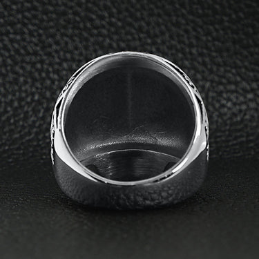 Stainless steel skull with Fleur De Lis pattern ring back view on a black leather background.