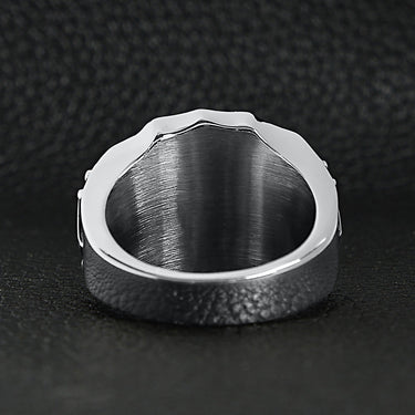 Stainless steel 18K gold PVD Coated Fleur De Lis shield ring back view on a black leather background.