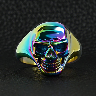 Stainless steel rainbow skull ring on a black leather background.