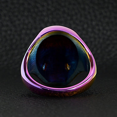 Stainless steel rainbow skull ring back view on a black leather background.