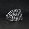 Stainless steel "BITCH" signet ring angled on a black leather background.