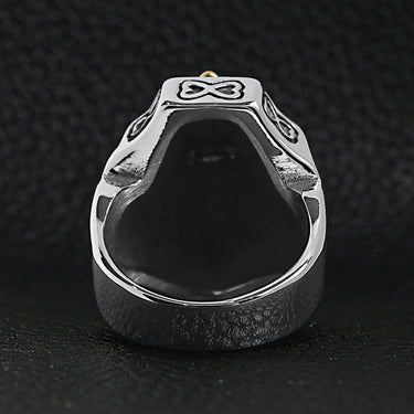 Stainless steel 18K gold PVD Coated Cross on shield signet ring back view on a black leather background.