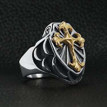 Stainless steel 18K gold PVD Coated Cross on shield signet ring angled on a black leather background.