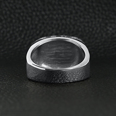 Stainless steel "FTW" middle finger signet ring back view on a black leather background.
