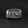 Stainless steel "FTW" middle finger signet ring on a black leather background.