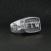 Stainless steel "FTW" middle finger signet ring angled on a black leather background.