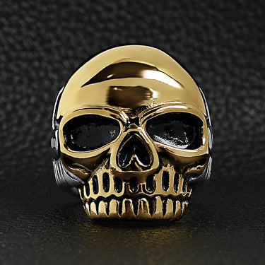 Stainless steel and 18K gold PVD Coated skull ring on a black leather background.