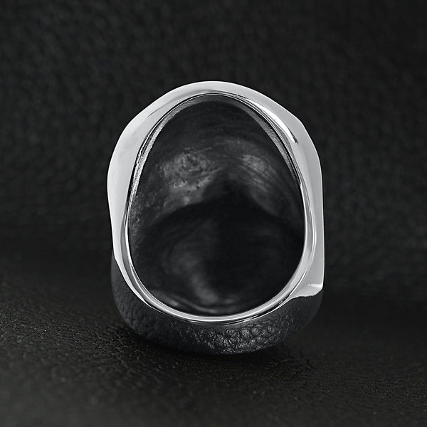 Stainless steel USA American flag covered skull ring back view on a black leather background.