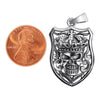 Sterling silver skull shield pendant with a penny for scale.