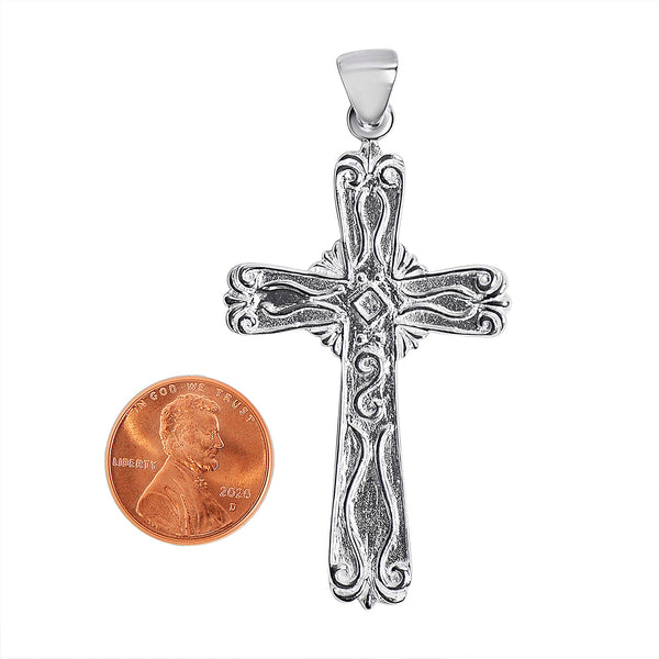 Sterling silver filigree cross pendant with a penny for scale.