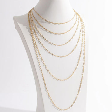 Gold chain necklace on a mannequin bust against a white background