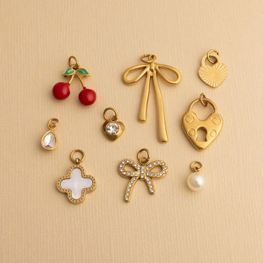Collection of gold charms on a beige background