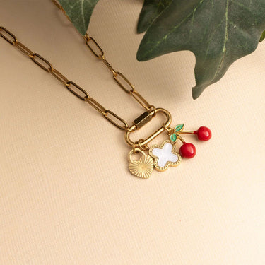 Gold necklace with charms on a beige background
