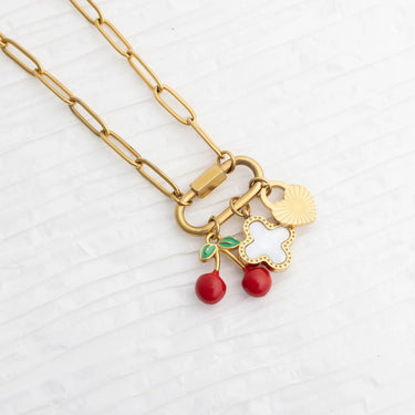 Gold necklace with cherry and heart charms on a white background