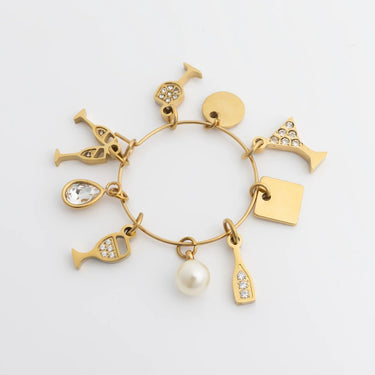 Gold bracelet with various charms on a light gray background