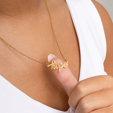 Gold Hope Necklace Gift Set with 'hope' pendant held by a hand