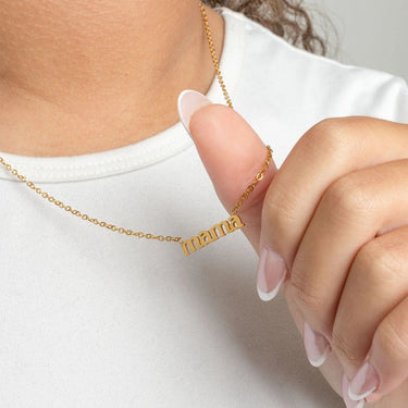 Gold Mama Necklace Gift Set being held by a hand against a white background