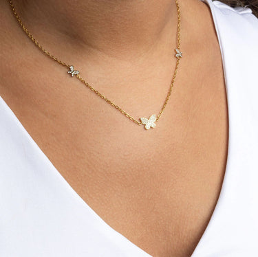 Gold Butterfly Necklace Gift Set with butterfly pendants on a person wearing a white top.
