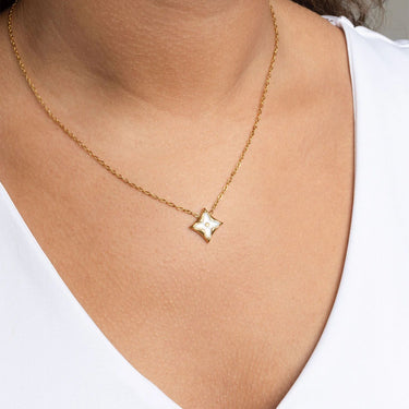 Gold Gold Mother Of Pearl Star Pendant Necklace Gift Set on a person wearing a white top.
