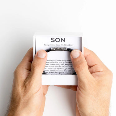 Hand holding a card with text on a white background with Silver Mens Leather Metal Clasp Bracelet Gift Set