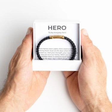 Gold Rubber Metal Clasp Bracelet Gift Set in a box labeled 'Hero' held by hands on a white background