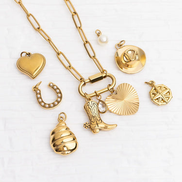 Gold necklace with various charms on a white background