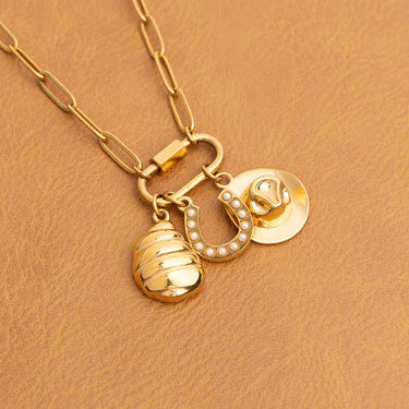 Gold necklace with charms on a brown background