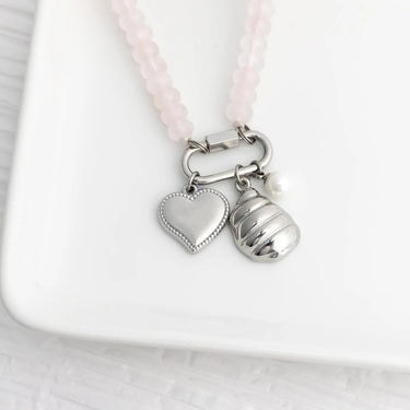 Necklace with heart and shell charms on a white background