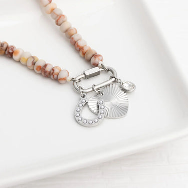 Necklace with beaded chain and silver heart-shaped pendants on a white background