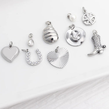 Collection of various silver charms on a white background