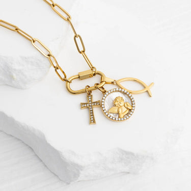 Gold necklace with charms on a white marble surface