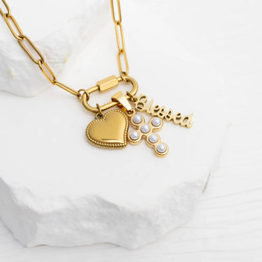 Gold necklace with heart and cross charms on a white background