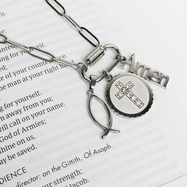 Silver necklace with religious charms on a book page
