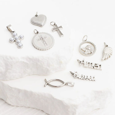 Collection of silver pendants on a white fabric background