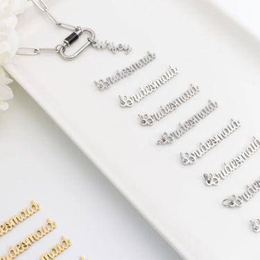 Silver 'Bridesmaid' charms on a white surface