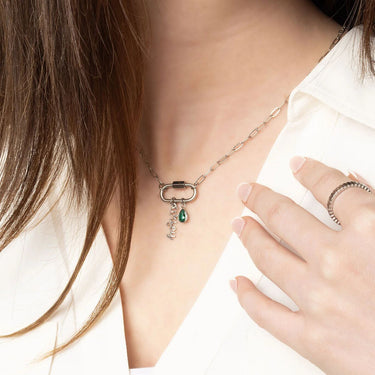 Necklace with a pendant worn by a person, with a hand touching the necklace.