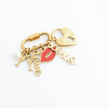Gold keychain with heart, lips, and 'love' charms on a white background