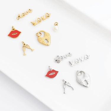 Collection of gold and silver charms on a white surface