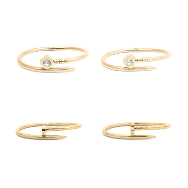 Set of four gold nail bangle bracelets with small gemstones on a white background