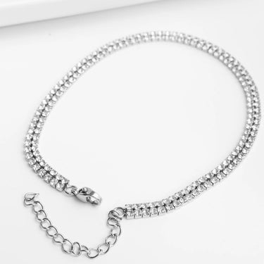 Silver chain necklace with clear stones on a white background