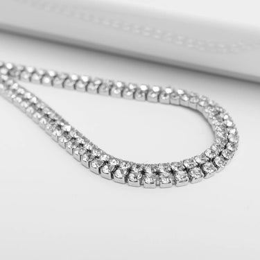 Silver chain with clear stones on a light gray background